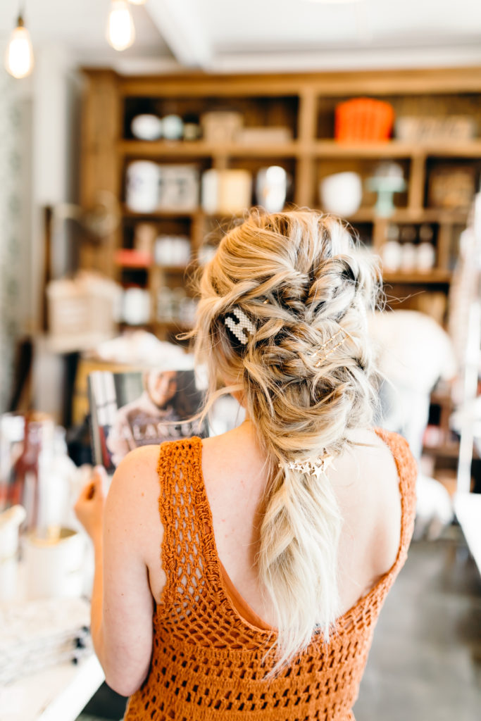 How to Wear Hair Clips by popular Nashville fashion blog, Nashville Wifestyles: image of a woman with a braided hairstyle and wearing a pearl letter H hair clip, gold bobby pins, and a star hair clip. 