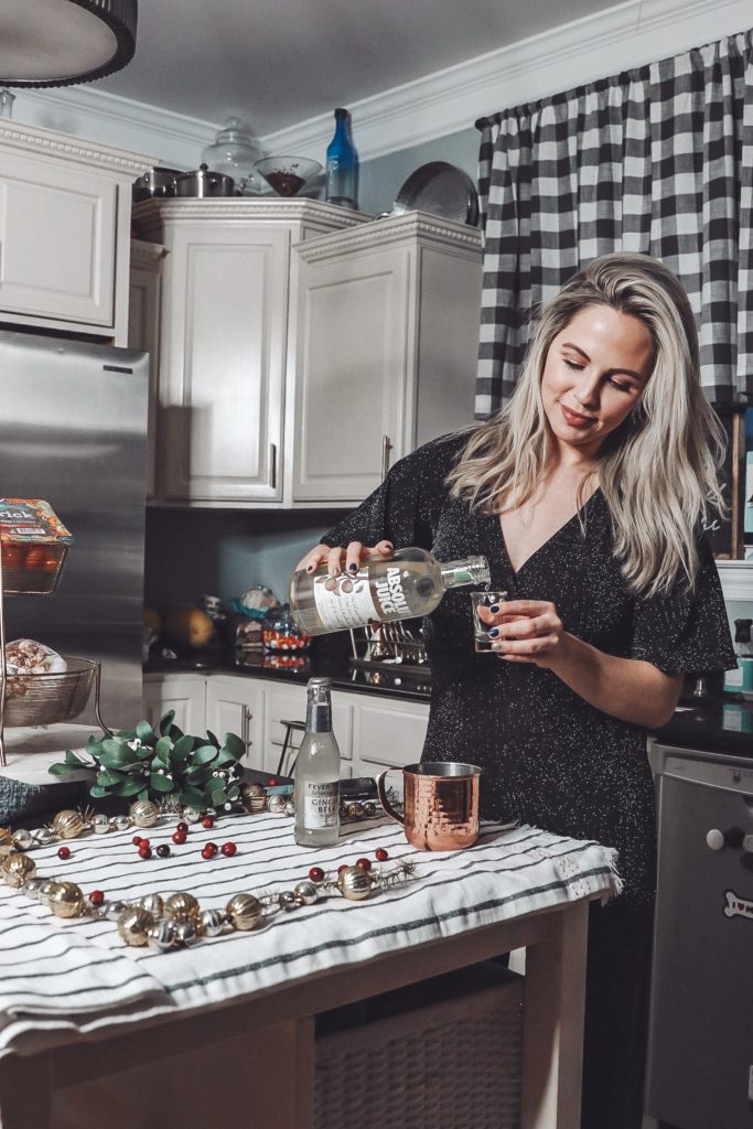 Holiday Moscow Mule || Apple Cranberry by popular Nashville life and style blog, Nashville Wifestyles: image of a woman making a holiday Moscow Mule.