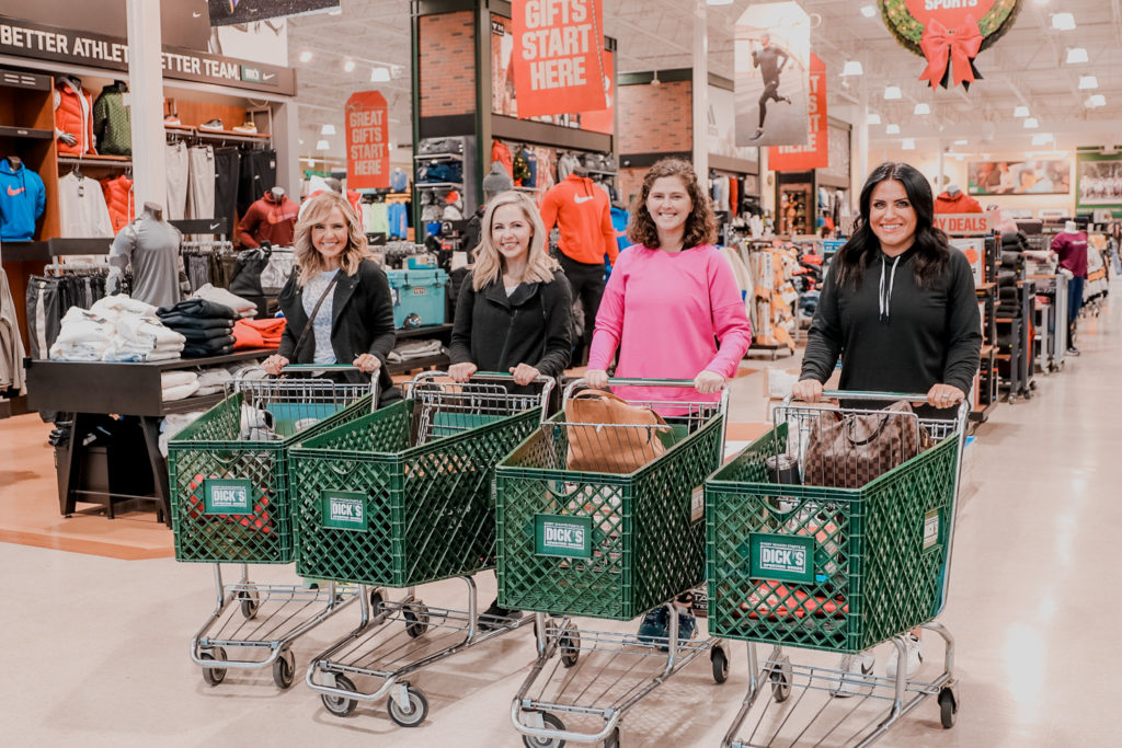 Last Minute Christmas Shopping Deals With Dick's Sporting Goods by popular Nashville life and style blog, Nashville Wifestyles: image of 4 woman standing next to each other and pushing Dick's Sporting Goods shopping carts. 