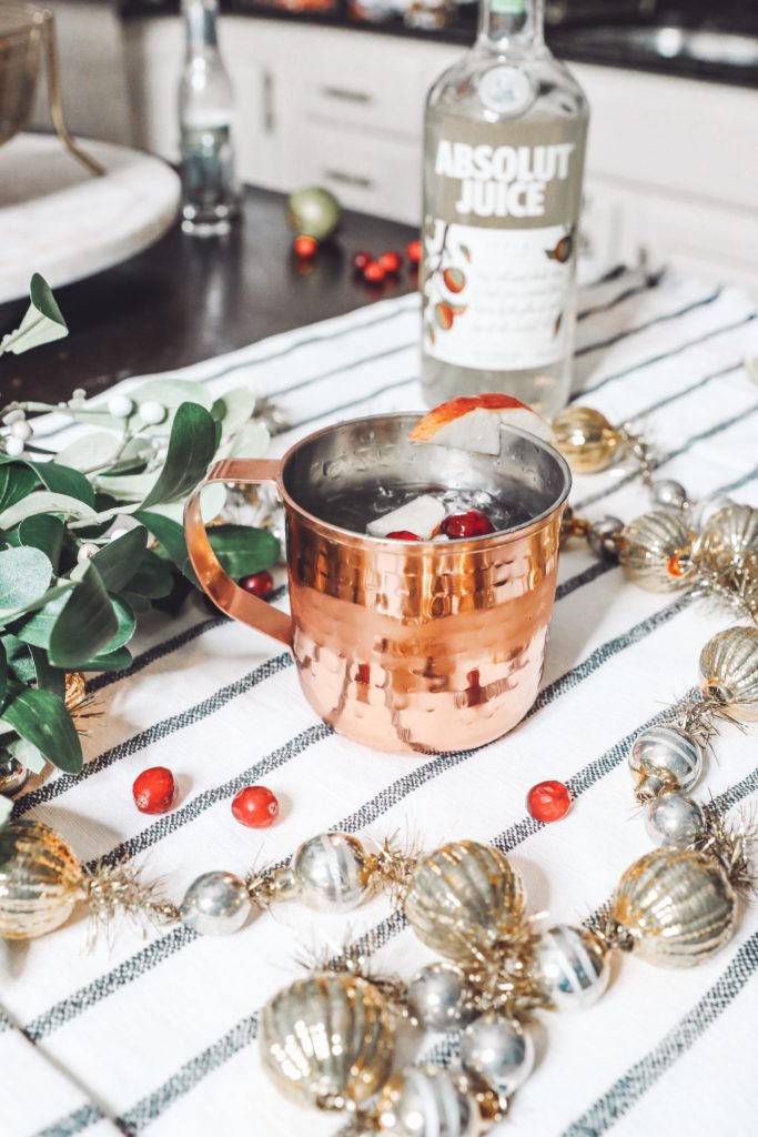 Holiday Moscow Mule || Apple Cranberry by popular Nashville life and style blog, Nashville Wifestyles: image of a copper mug filled with a holiday Moscow Mule.
