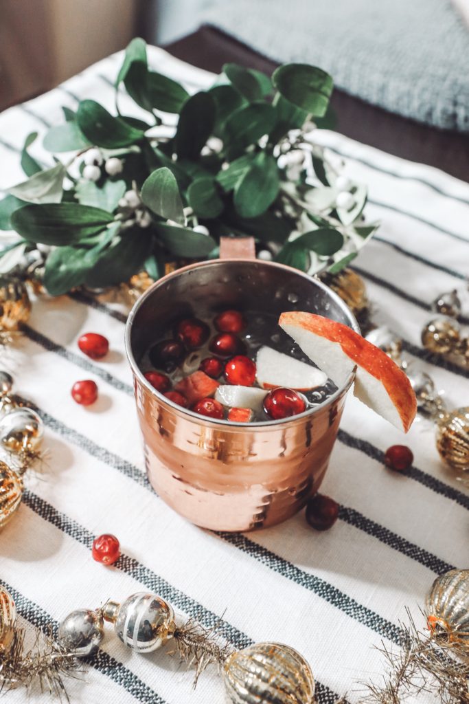 Holiday Moscow Mule || Apple Cranberry by popular Nashville life and style blog, Nashville Wifestyles: image of a copper mug filled with a Moscow Mule.