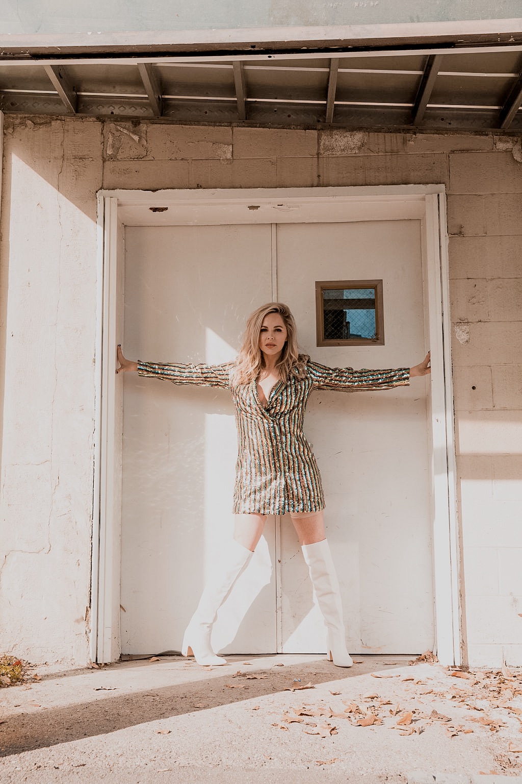 Rocking the Blazer Dress trend by popular Nashville fashion blog, Nashville Wifestyles: image of a woman wearing a sequin blazer dress and over-the-knee white boots.