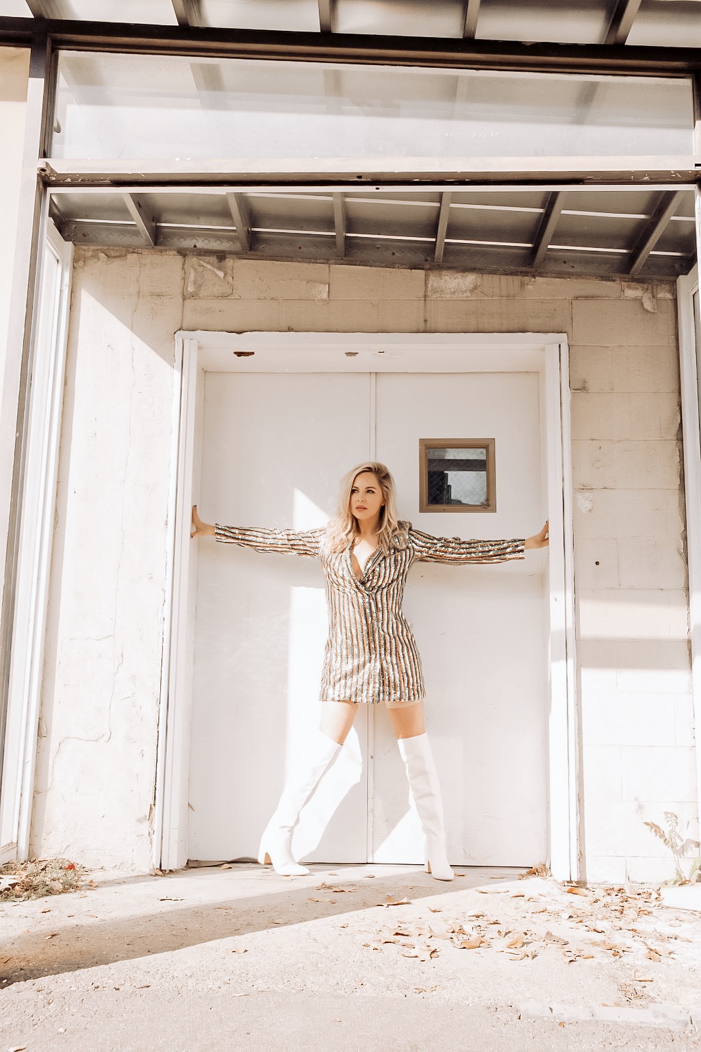 Rocking the Blazer Dress trend by popular Nashville fashion blog, Nashville Wifestyles: image of a woman wearing a sequin blazer dress and over-the-knee white boots.