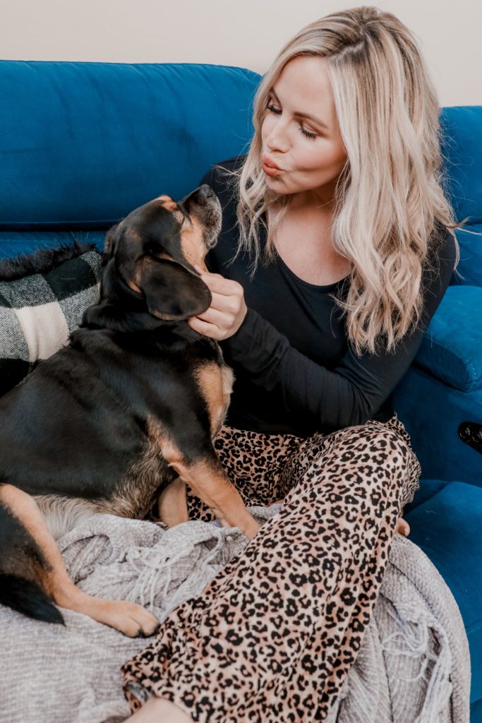 Pet Parent by popular Nashville lifestyle blog, Nashville Wifestyles: image of a woman sitting on a blue couch with her dog in her lap. 