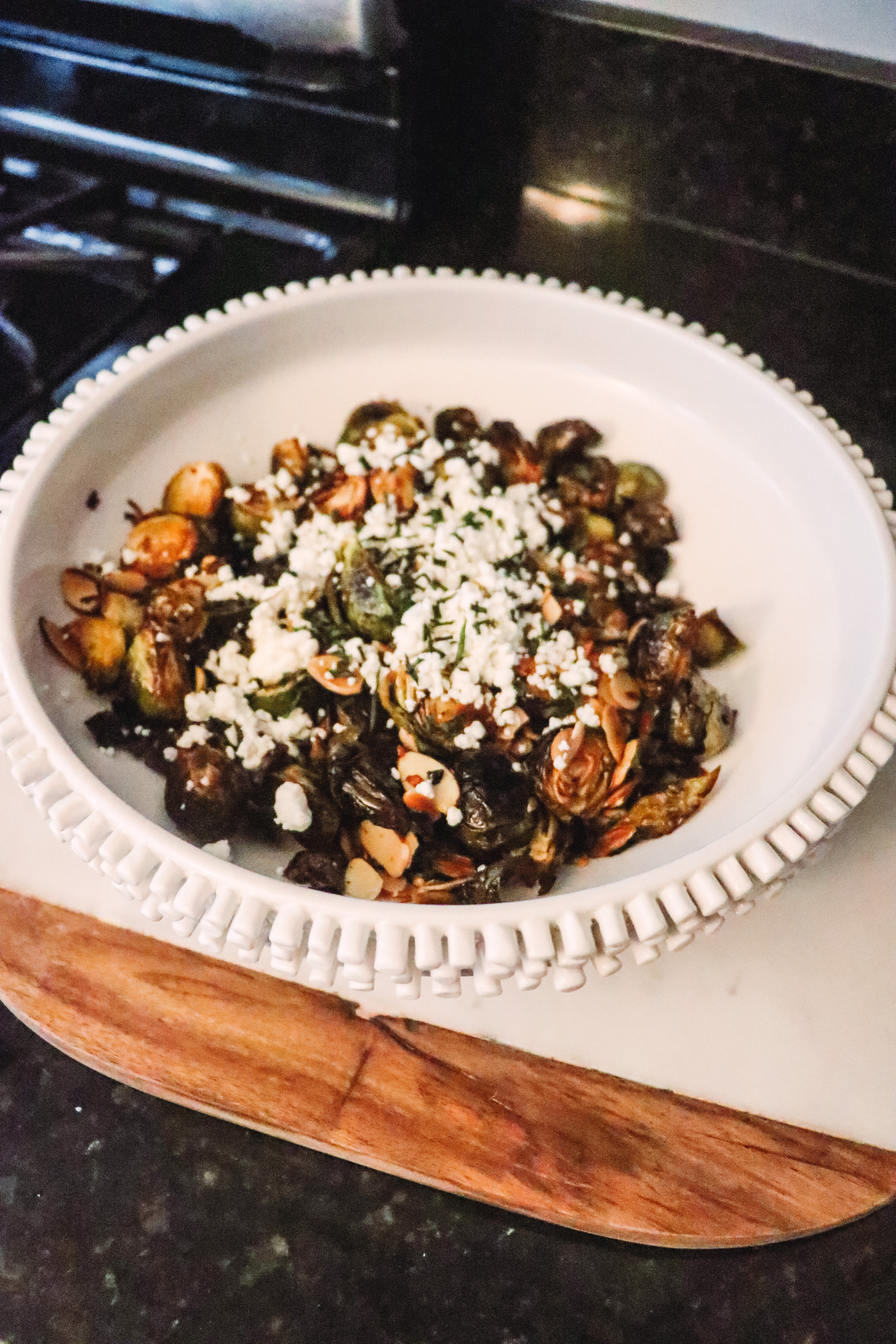 Honey Roasted Brussel Sprouts by popular Nashville life and style blog, Nashville Wifestyles: image of a a white ceramic bowl containing honey roasted Brussel sprouts.
