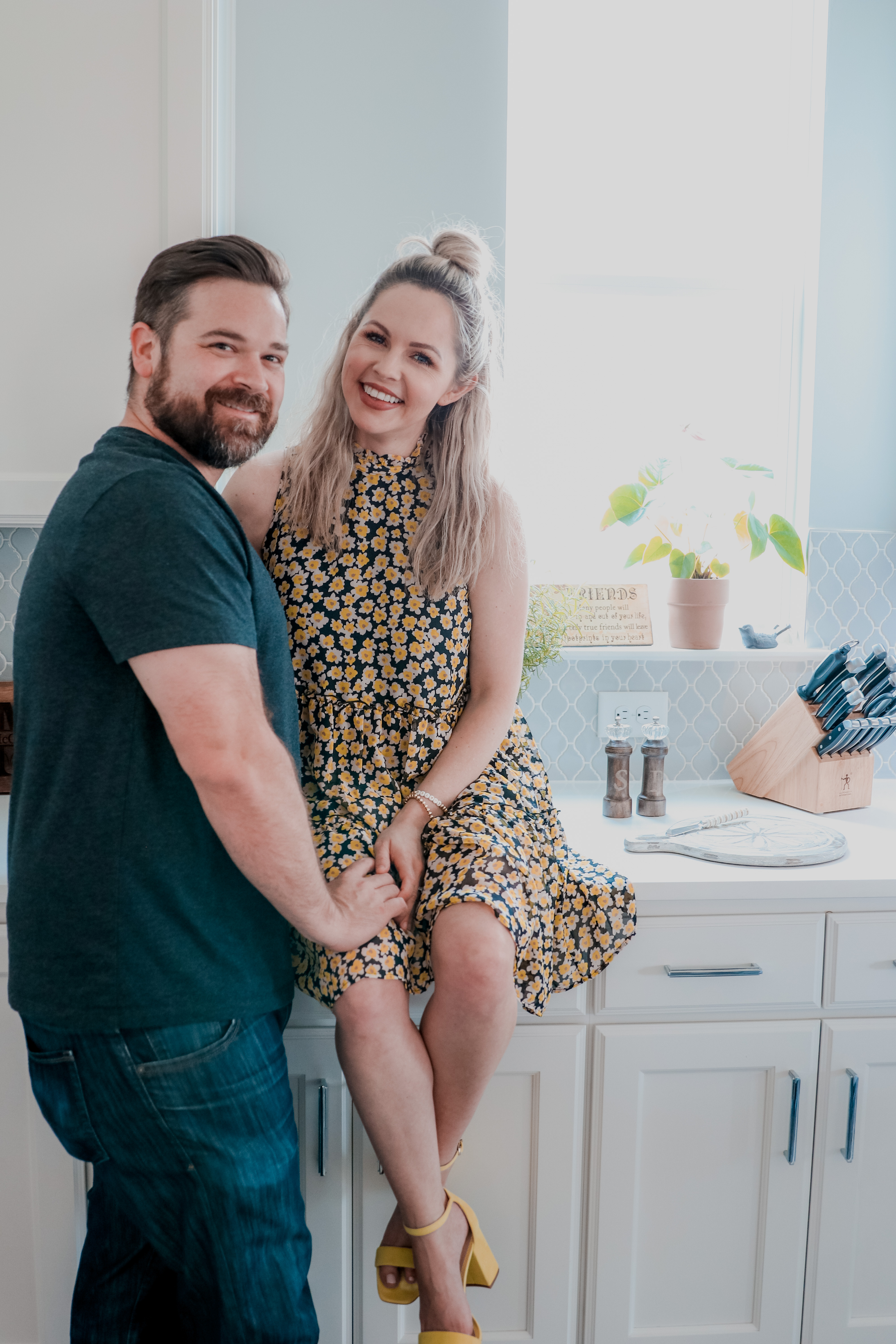 Date Night In Ideas by popular Nashville lifestyle blog, Nashville Wifestyles: image of a man standing next to a woman who is sitting on a kitchen counter.