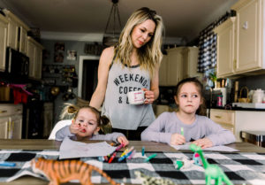 Homemade Mothers Day Gifts From Child by popular Nashville lifestyle blog, Nashville Wifestyles: image of a mom sitting at a farmhouse table with her two daughters while they work on some crafts.