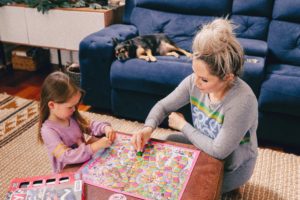 Family Board Games by popular Nashville motherhood blog, Nashville Wifestyles: image of a woman playing Candyland with her daughter.