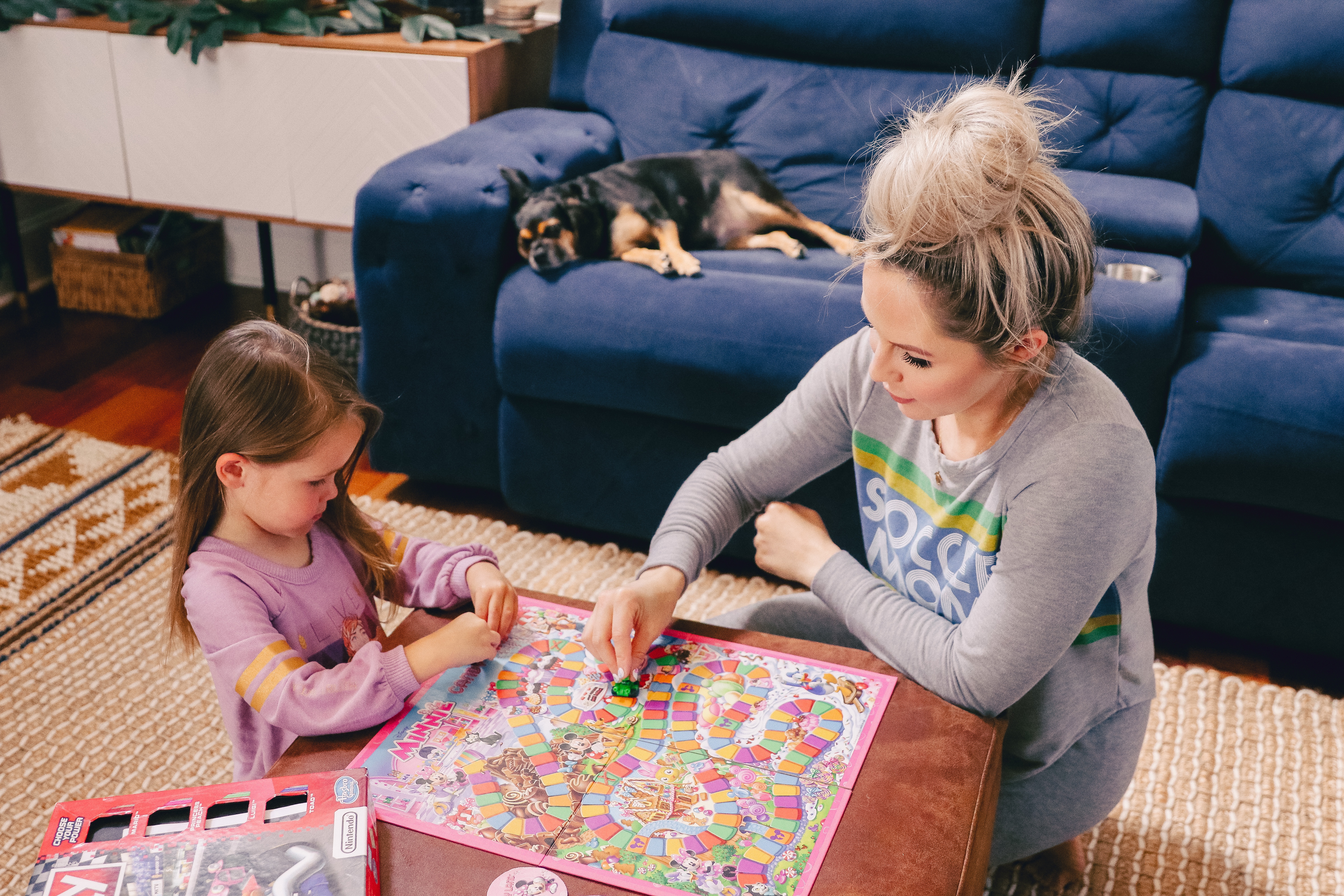Family Board Games by popular Nashville motherhood blog, Nashville Wifestyles: image of a woman playing Candyland with her daughter.