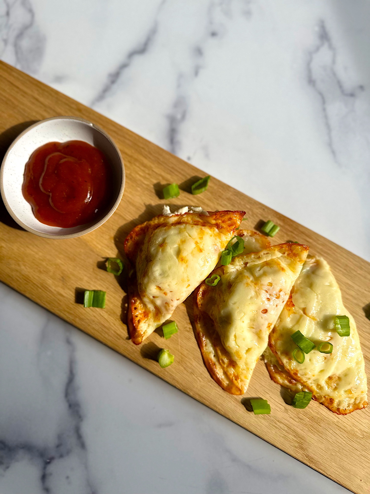 Creamy low-carb crab Rangoon filling with scallions and garlic powder in a white bowl